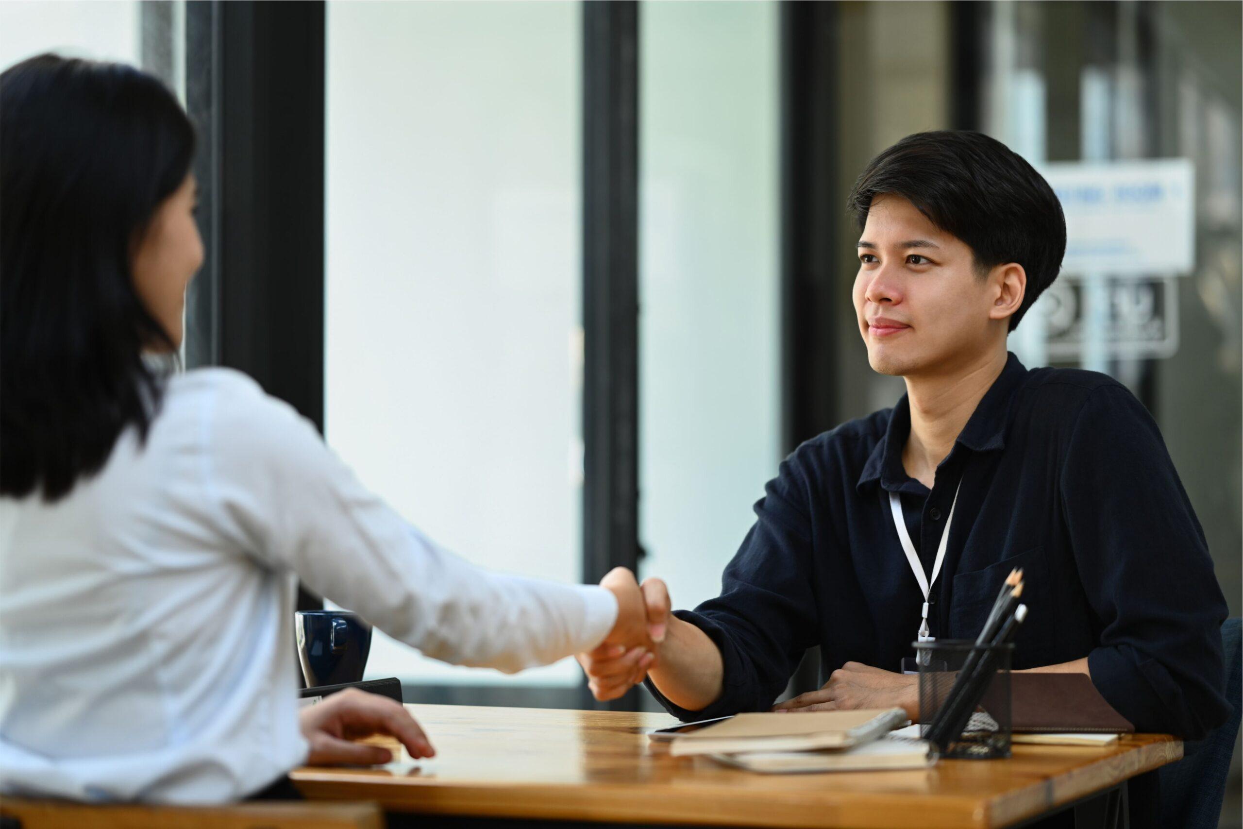 smiling-asian-male-manager-shaking-hands-at-briefi-2024-04-01-18-17-16-utc 1